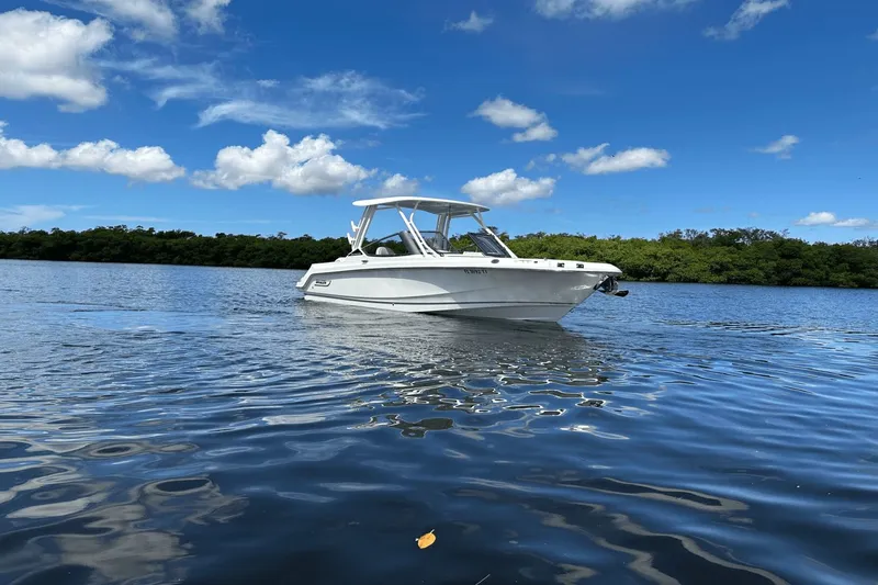 Yacht Photos Pics 2023 Boston Whaler 240 Vantage boat on calm water under blue sky.