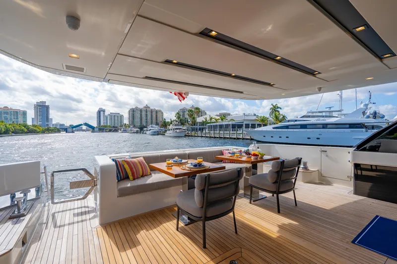 Sweet Virginia Yacht Photos Pics Luxurious 2023 Sanlorenzo SL96A yacht deck with dining area, overlooking waterfront cityscape.