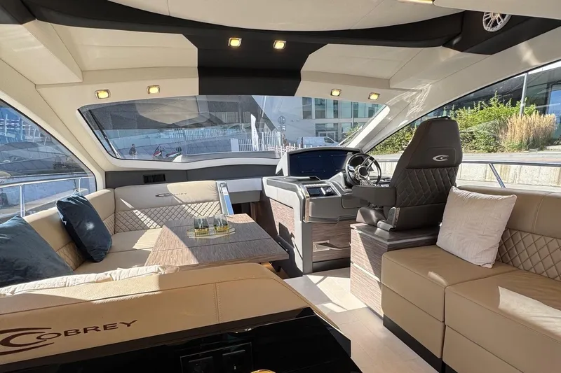  Yacht Photos Pics Luxurious interior of 2025 Cobrey 50 FLY yacht with elegant seating and modern helm.