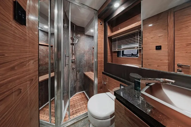  Yacht Photos Pics Luxurious bathroom in 2025 Cobrey 50 FLY yacht with modern shower and sleek wood finishes.