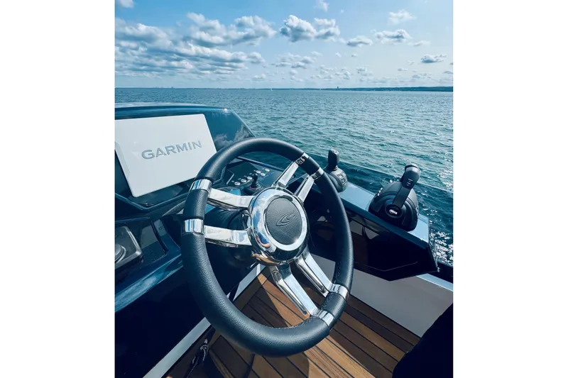  Yacht Photos Pics Steering wheel of 2025 Cobrey 50 FLY yacht with Garmin navigation, ocean view.