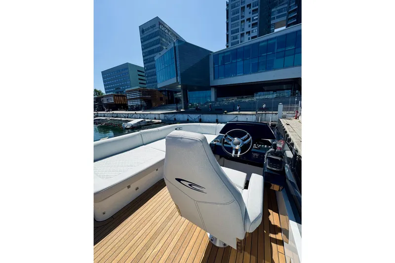  Yacht Photos Pics 2025 Cobrey 50 FLY yacht interior with modern steering, docked near contemporary buildings.