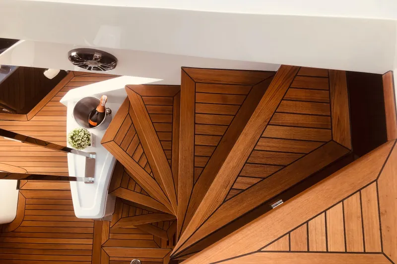  Yacht Photos Pics Luxurious wooden staircase on 2025 Cobrey 50 FLY yacht with champagne and flowers.