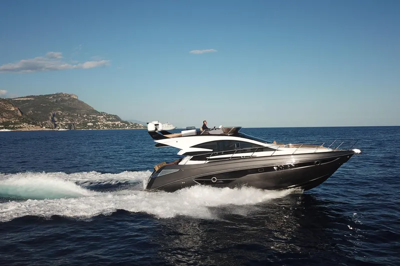  Yacht Photos Pics 2025 Cobrey 50 FLY yacht cruising on open sea with scenic coastal backdrop.