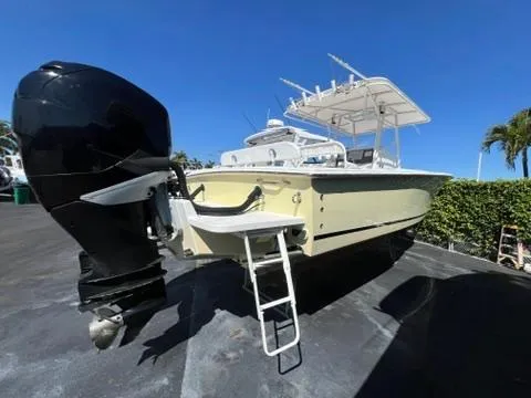  Yacht Photos Pics 2006 Jupiter 31 Center Console boat with outboard motor and ladder, parked outdoors.