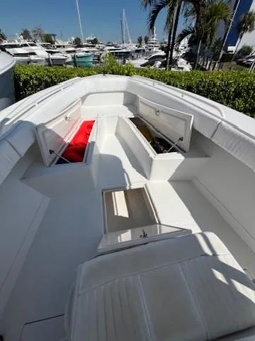  Yacht Photos Pics 2006 Jupiter 31 Center Console boat with open storage compartments, docked near palm trees and yachts.