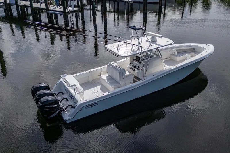  Yacht Photos Pics 2016 Invincible 39 Open Fisherman boat with triple Mercury engines on calm water.