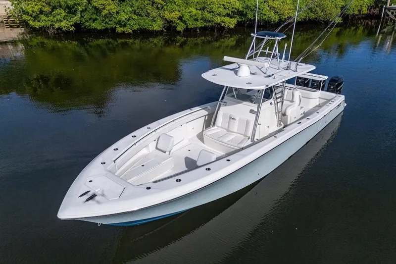  Yacht Photos Pics 2016 Invincible 39 Open Fisherman boat on calm water, surrounded by lush greenery.