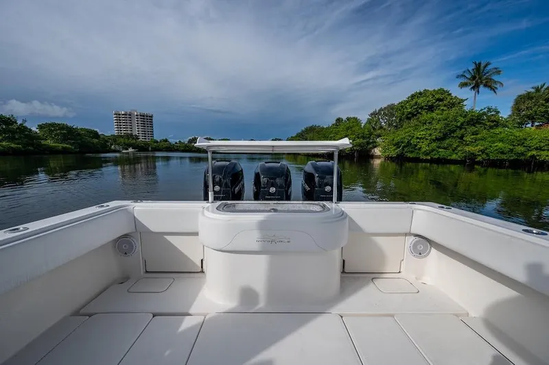  Yacht Photos Pics 2016 Invincible 39 Open Fisherman boat on calm water, surrounded by lush greenery.