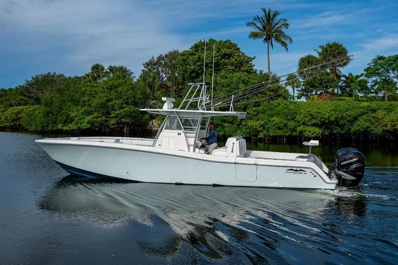  Yacht Photos Pics 2016 Invincible 39 Open Fisherman boat cruising on a calm river with lush greenery.