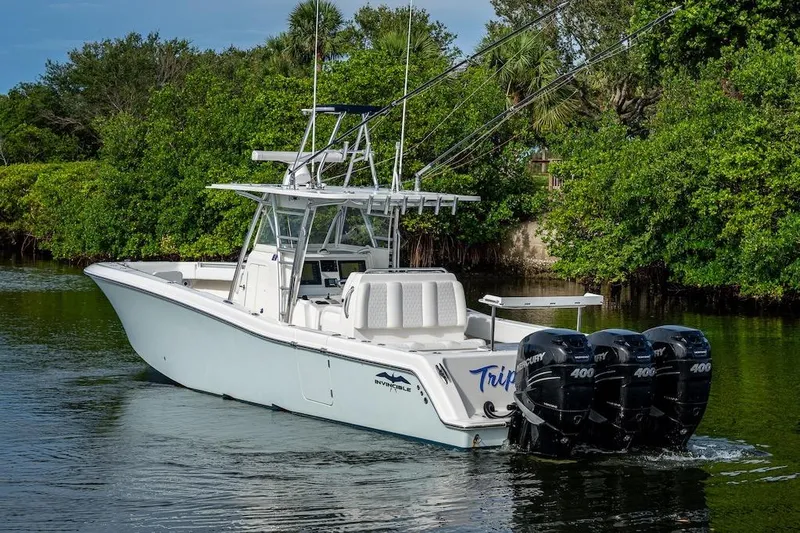  Yacht Photos Pics 2016 Invincible 39 Open Fisherman boat with triple Mercury 400 engines on a calm waterway.