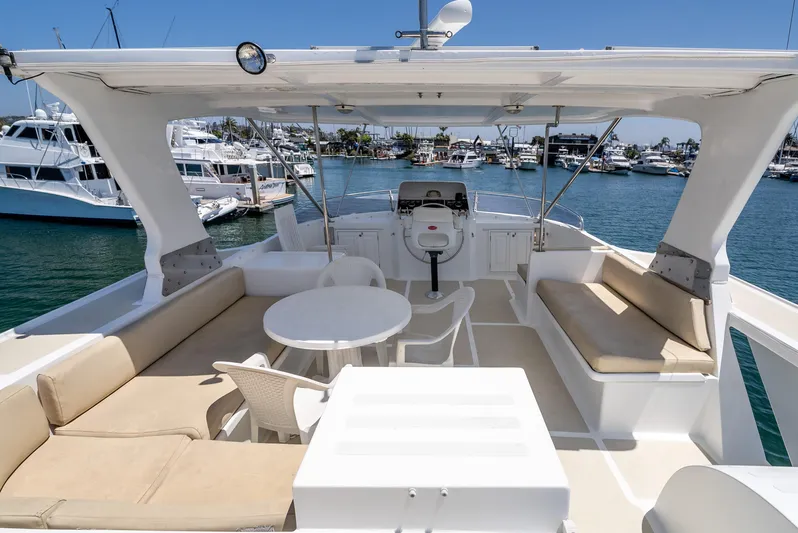 Si Como No Yacht Photos Pics Flybridge of 2009 DeFever 45 Motoryacht with seating and table, docked in marina.