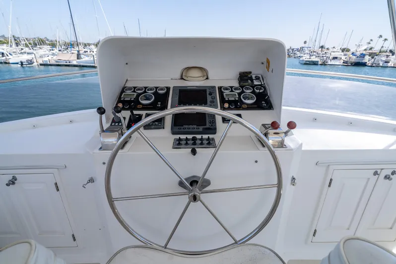 Si Como No Yacht Photos Pics Helm of 2009 DeFever 45 Motoryacht with steering wheel and control panel, docked in marina.