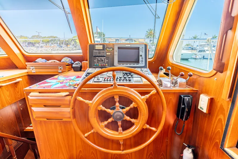 Si Como No Yacht Photos Pics Helm of 2009 DeFever 45 Motoryacht with wooden wheel and navigation equipment.