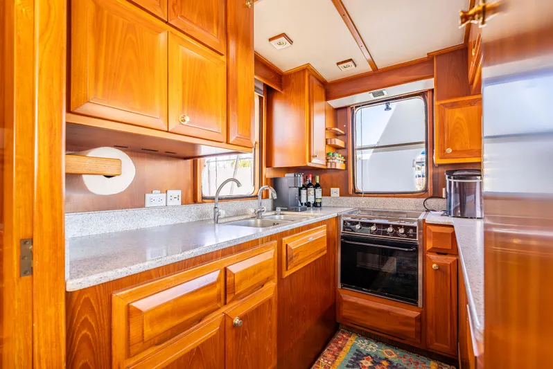 Si Como No Yacht Photos Pics Luxurious 2009 DeFever 45 Motoryacht kitchen with wooden cabinetry and modern appliances.