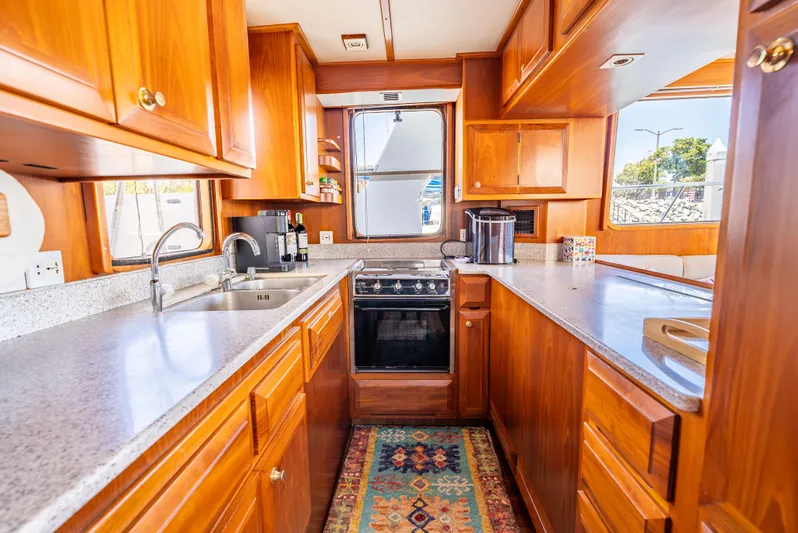 Si Como No Yacht Photos Pics Luxurious kitchen interior of 2009 DeFever 45 Motoryacht with wooden cabinetry and modern appliances.