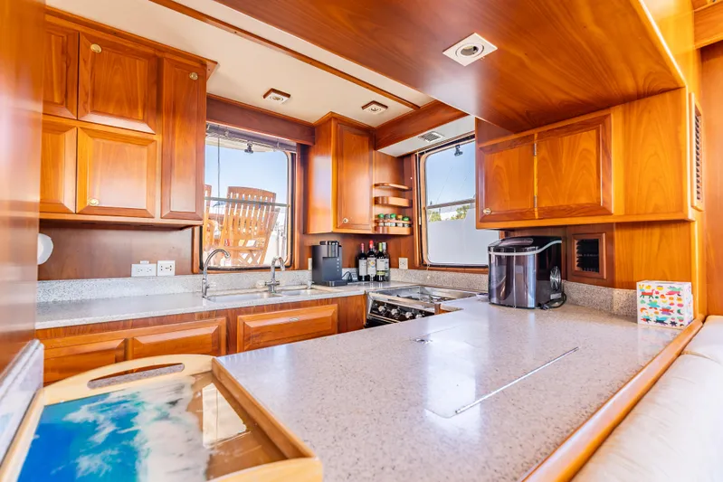 Si Como No Yacht Photos Pics Luxurious kitchen interior of 2009 DeFever 45 Motoryacht with wooden cabinetry and modern appliances.