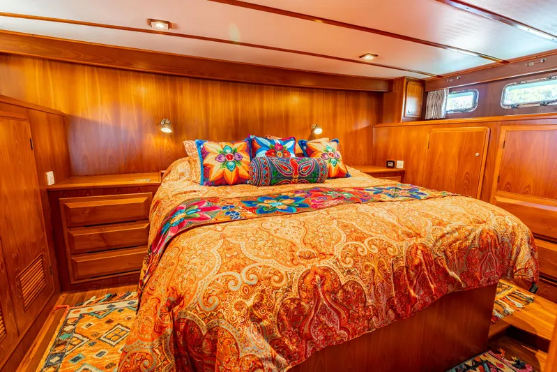 Si Como No Yacht Photos Pics Luxurious 2009 DeFever 45 Motoryacht bedroom with vibrant bedding and rich wood paneling.
