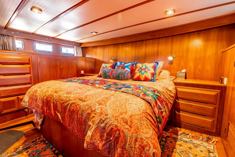 Si Como No Yacht Photos Pics Luxurious 2009 DeFever 45 Motoryacht bedroom with vibrant bedding and wooden interior.