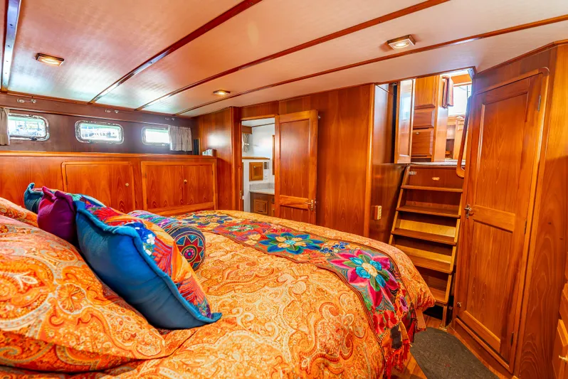Si Como No Yacht Photos Pics Luxurious 2009 DeFever 45 Motoryacht cabin with vibrant bedding and rich wood paneling.