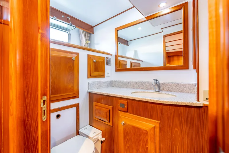 Si Como No Yacht Photos Pics Luxurious bathroom in 2009 DeFever 45 Motoryacht with wooden cabinetry and granite countertop.
