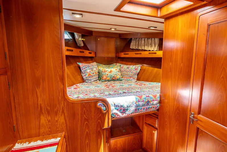 Si Como No Yacht Photos Pics Cozy cabin interior of 2009 DeFever 45 Motoryacht with vibrant bedding and wood finish.
