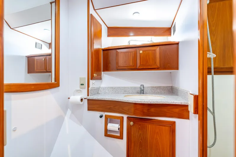 Si Como No Yacht Photos Pics Luxurious bathroom in 2009 DeFever 45 Motoryacht with wooden cabinets and modern fixtures.