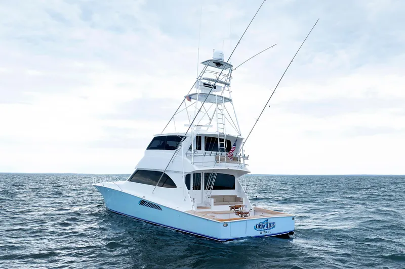 On Ice Yacht Photos Pics 2009 Viking 74 Enclosed Bridge yacht cruising on open sea under cloudy sky.