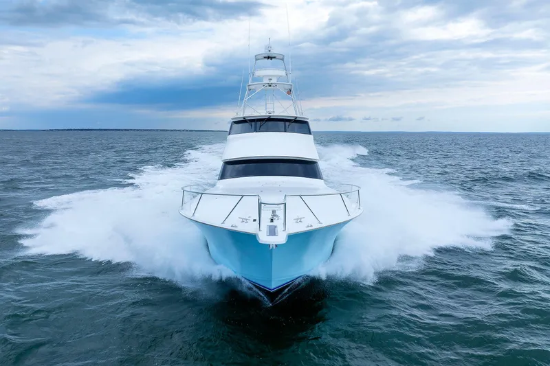 On Ice Yacht Photos Pics 2009 Viking 74 Enclosed Bridge yacht cruising on open sea under cloudy sky.