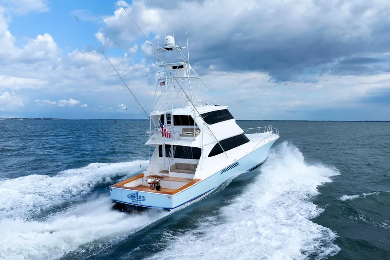 On Ice Yacht Photos Pics 2009 Viking 74 Enclosed Bridge yacht cruising on open water under cloudy skies.