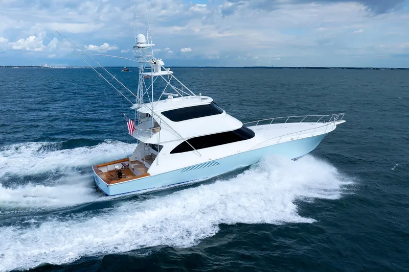 On Ice Yacht Photos Pics 2009 Viking 74 Enclosed Bridge yacht cruising on open sea under cloudy sky.