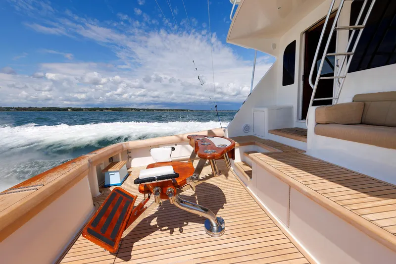 On Ice Yacht Photos Pics 2009 Viking 74 Enclosed Bridge yacht deck with fishing chair, ocean view, and clear sky.