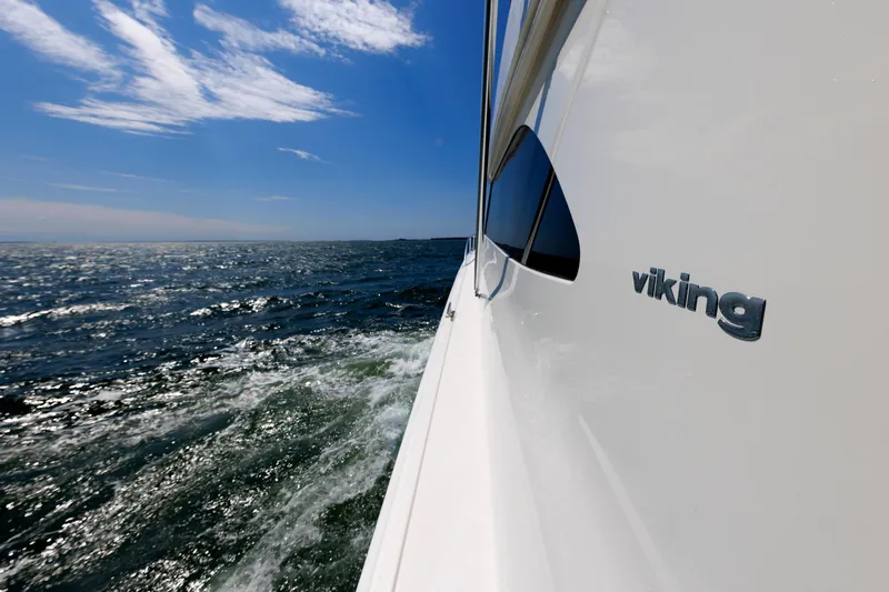 On Ice Yacht Photos Pics 2009 Viking 74 Enclosed Bridge yacht cruising on open sea under blue sky.