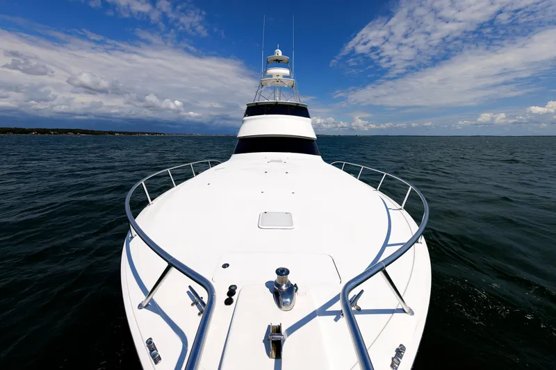 On Ice Yacht Photos Pics 2009 Viking 74 Enclosed Bridge yacht cruising on open water under blue sky.