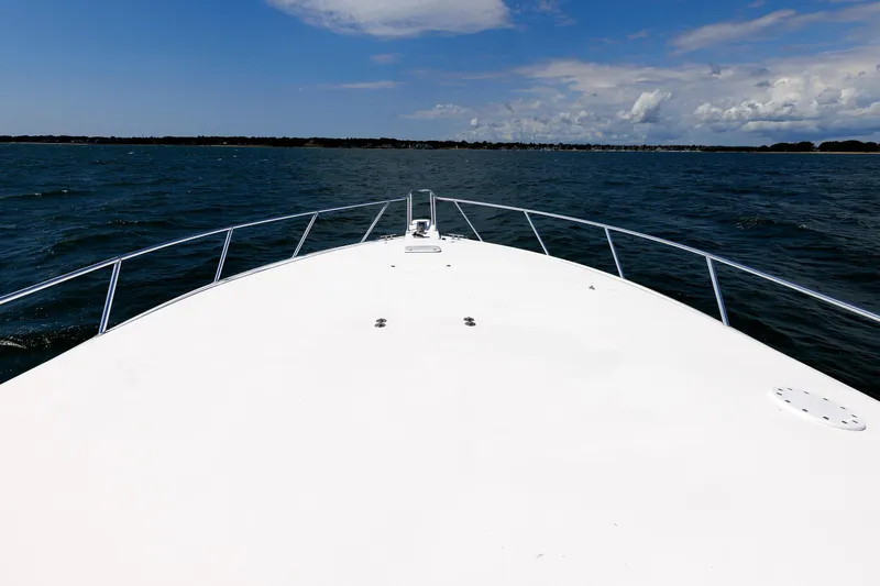 On Ice Yacht Photos Pics Bow view of 2009 Viking 74 Enclosed Bridge yacht on open water under blue sky.