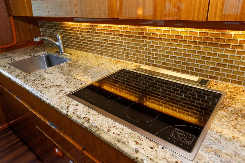 On Ice Yacht Photos Pics Luxurious kitchen in 2009 Viking 74 Enclosed Bridge yacht with granite countertops and modern appliances.