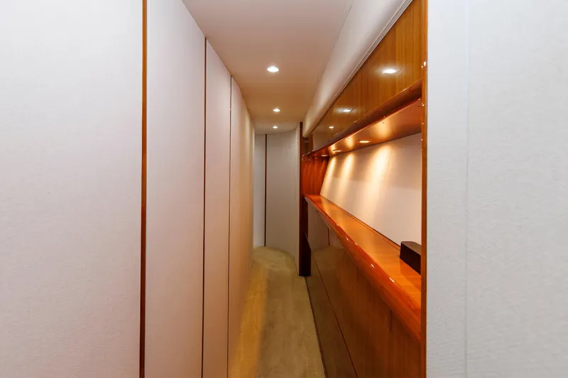 On Ice Yacht Photos Pics Narrow hallway inside 2009 Viking 74 Enclosed Bridge yacht with wooden accents and recessed lighting.