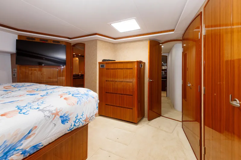 On Ice Yacht Photos Pics Luxurious bedroom interior of 2009 Viking 74 Enclosed Bridge yacht with wood finishes and TV.