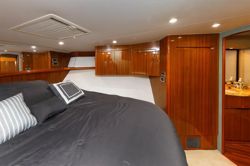On Ice Yacht Photos Pics Luxurious bedroom interior of 2009 Viking 74 Enclosed Bridge yacht with wood paneling.