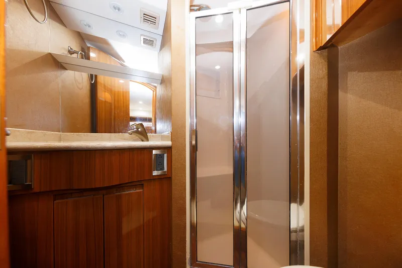 On Ice Yacht Photos Pics Luxurious bathroom interior of 2009 Viking 74 Enclosed Bridge yacht with wood accents and modern fixtures.