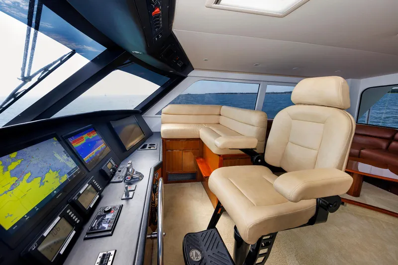 On Ice Yacht Photos Pics Luxurious 2009 Viking 74 Enclosed Bridge yacht interior with navigation screens and plush seating.