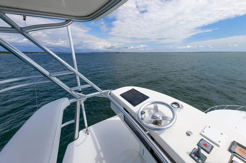 On Ice Yacht Photos Pics 2009 Viking 74 Enclosed Bridge yacht helm overlooking open sea and cloudy sky.
