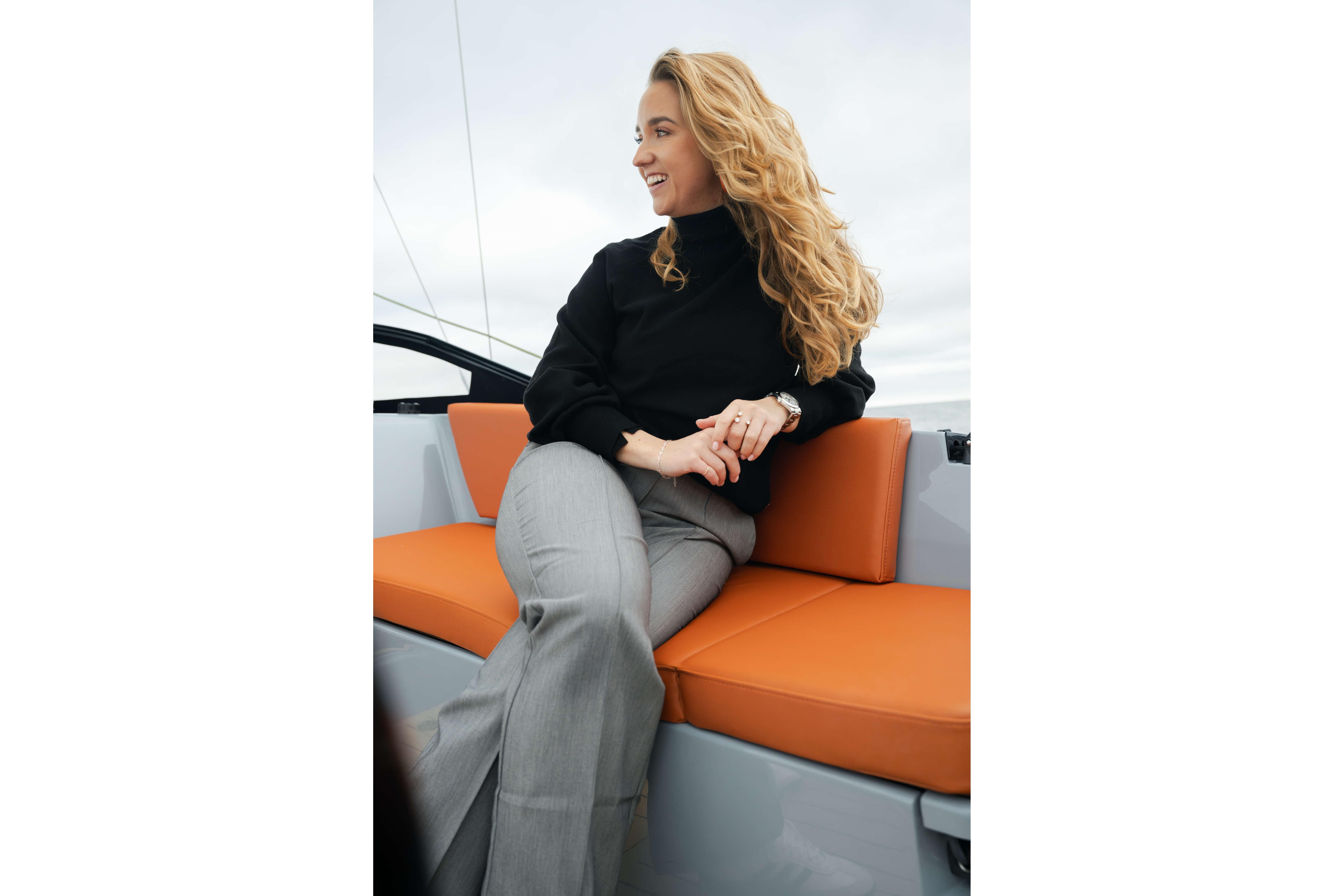 Woman sitting on Saffier SE 28 Leopard yacht, 2026 model, with orange seating.