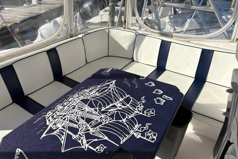 Andiamo Yacht Photos Pics Interior of 2001 Ocean 40 Express Bridge with nautical-themed table cover and striped seating.