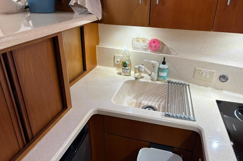 Andiamo Yacht Photos Pics Compact kitchen area in a 2001 Ocean 40 Express Bridge yacht, featuring a sink and countertop.