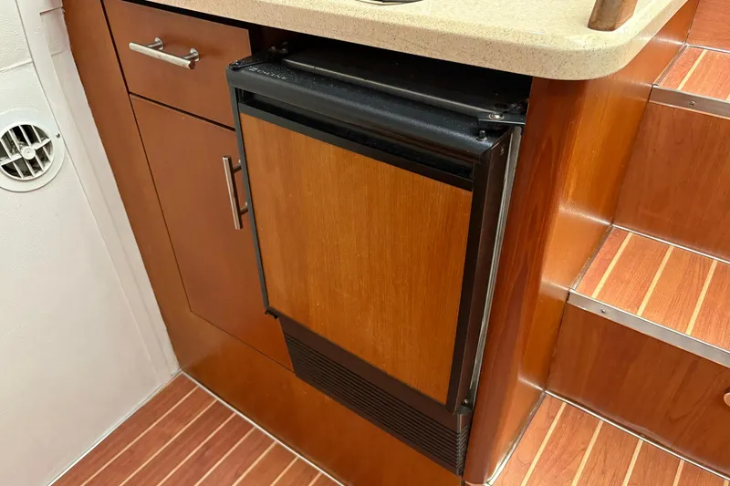 Andiamo Yacht Photos Pics 2001 Ocean 40 Express Bridge interior with wooden cabinetry and compact fridge.