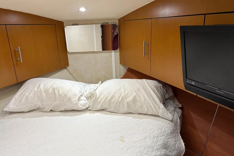 Andiamo Yacht Photos Pics Cozy cabin interior of 2001 Ocean 40 Express Bridge with bed, wooden cabinets, and TV.