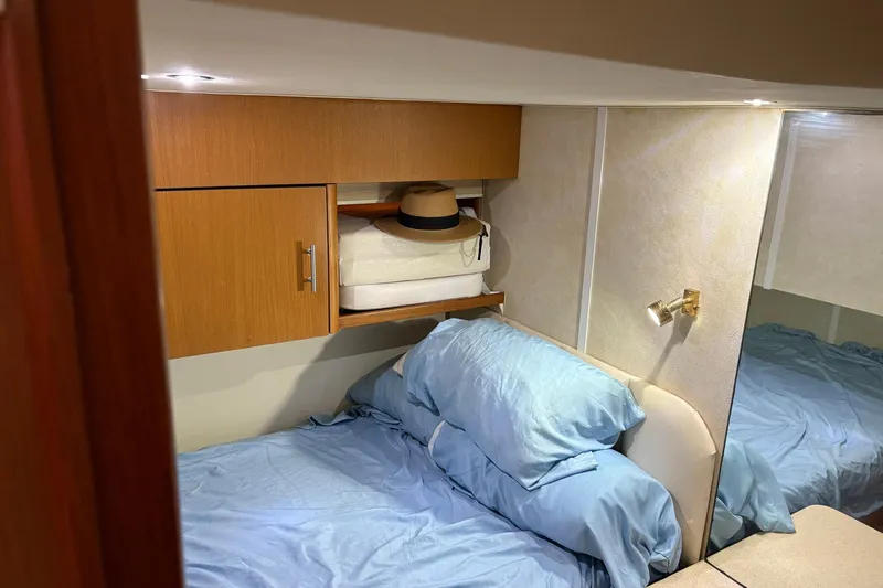 Andiamo Yacht Photos Pics Cozy cabin interior of 2001 Ocean 40 Express Bridge with blue bedding and wooden cabinets.