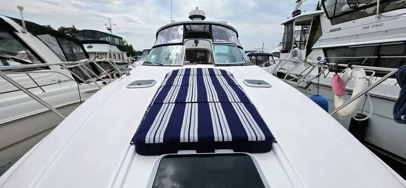  Yacht Photos Pics 2007 Rinker 350 Express yacht with striped deck cushions, docked among other boats.