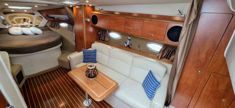  Yacht Photos Pics 2007 Rinker 350 Express cabin interior with bed, sofa, and wooden cabinetry.